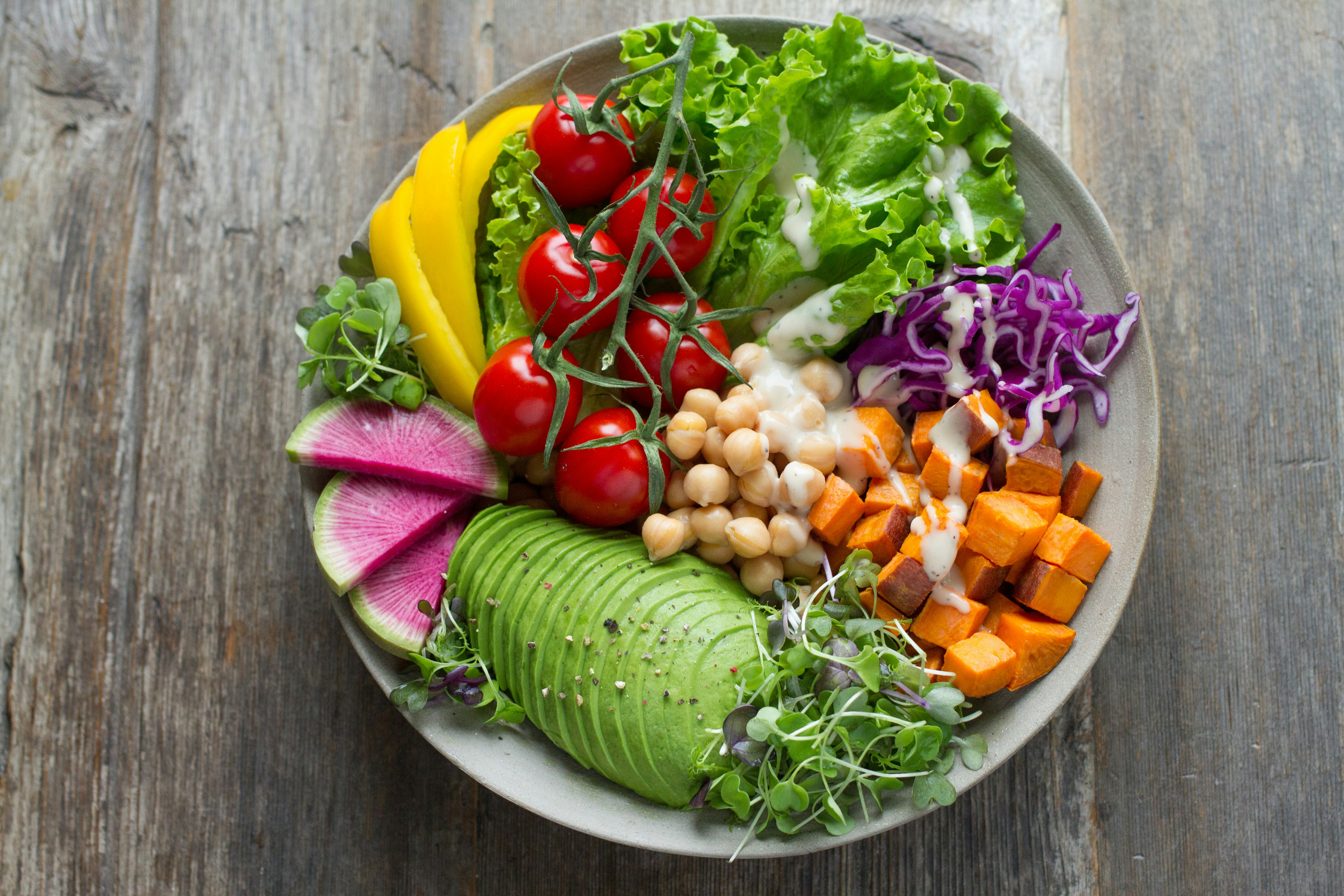 A colorful bowl of fresh vegetables, avocado, and chickpeas representing healthy nutrition